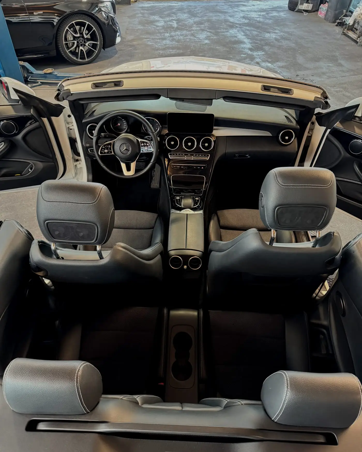 Innenraum eines Mercedes Cabriolets von oben fotografiert: Vordersitze, Rückbank und Mittelkonsole, sauber aufbereitet